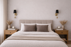 Neatly made bed with beige bedding and pillows in a bedroom setting.