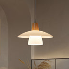 Pendant light with wooden top and white shade hanging against a neutral wall.