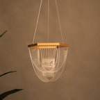 Modern pendant light with wooden accent against a brown wall