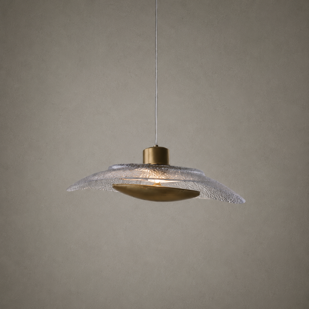 Pendant light with textured glass shade and brass fixture on a neutral background