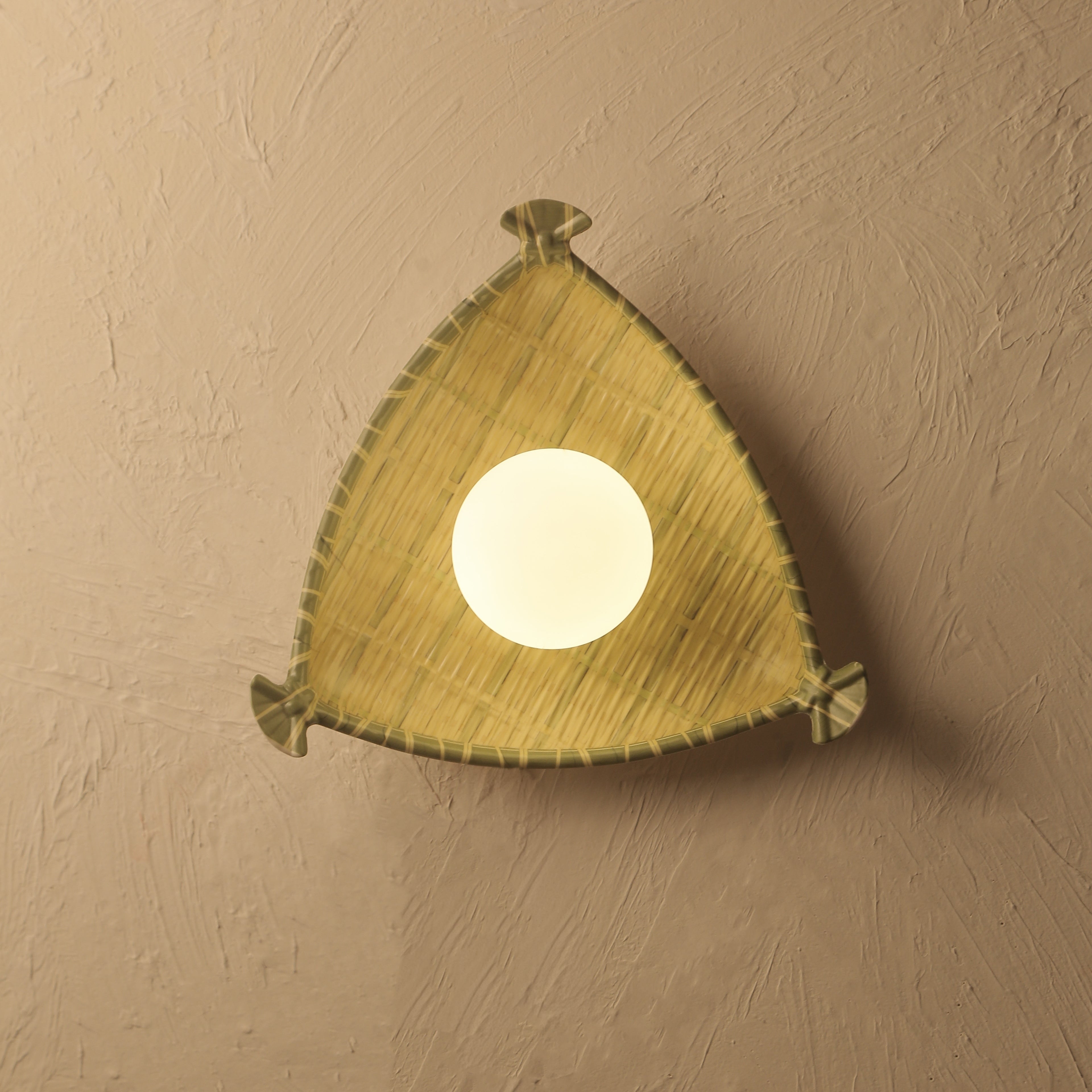 Triangular wall light fixture on a beige wall