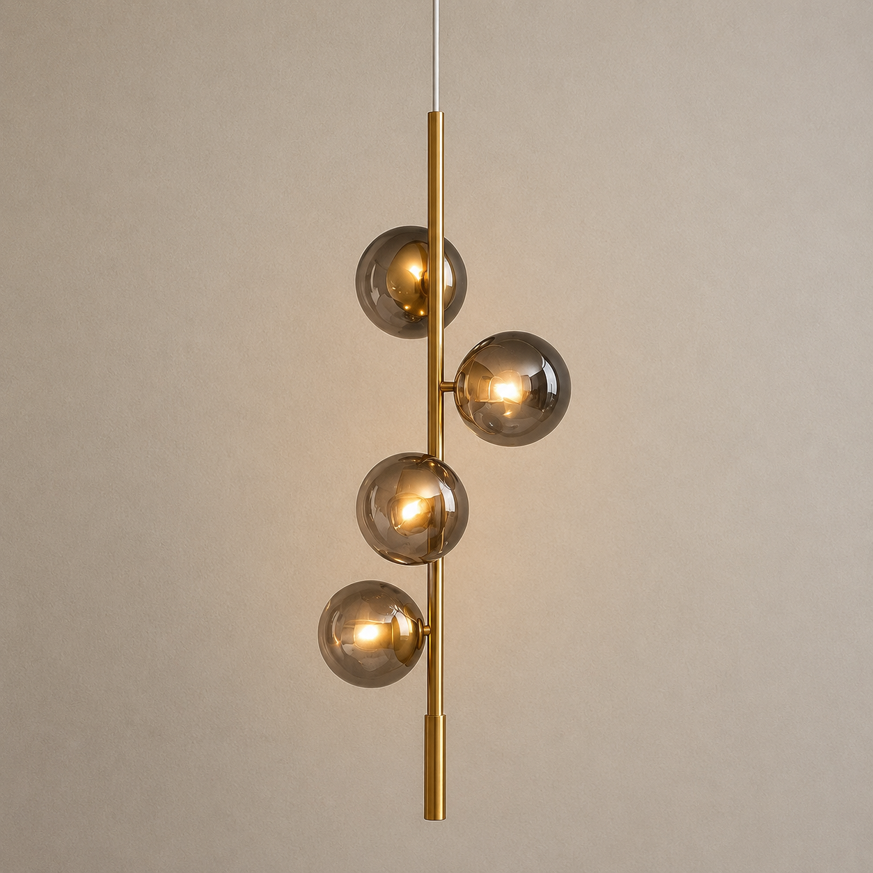 Modern pendant light with glass spheres and gold fixture on a neutral background