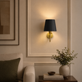 Wall sconce with black shade in a living room setting
