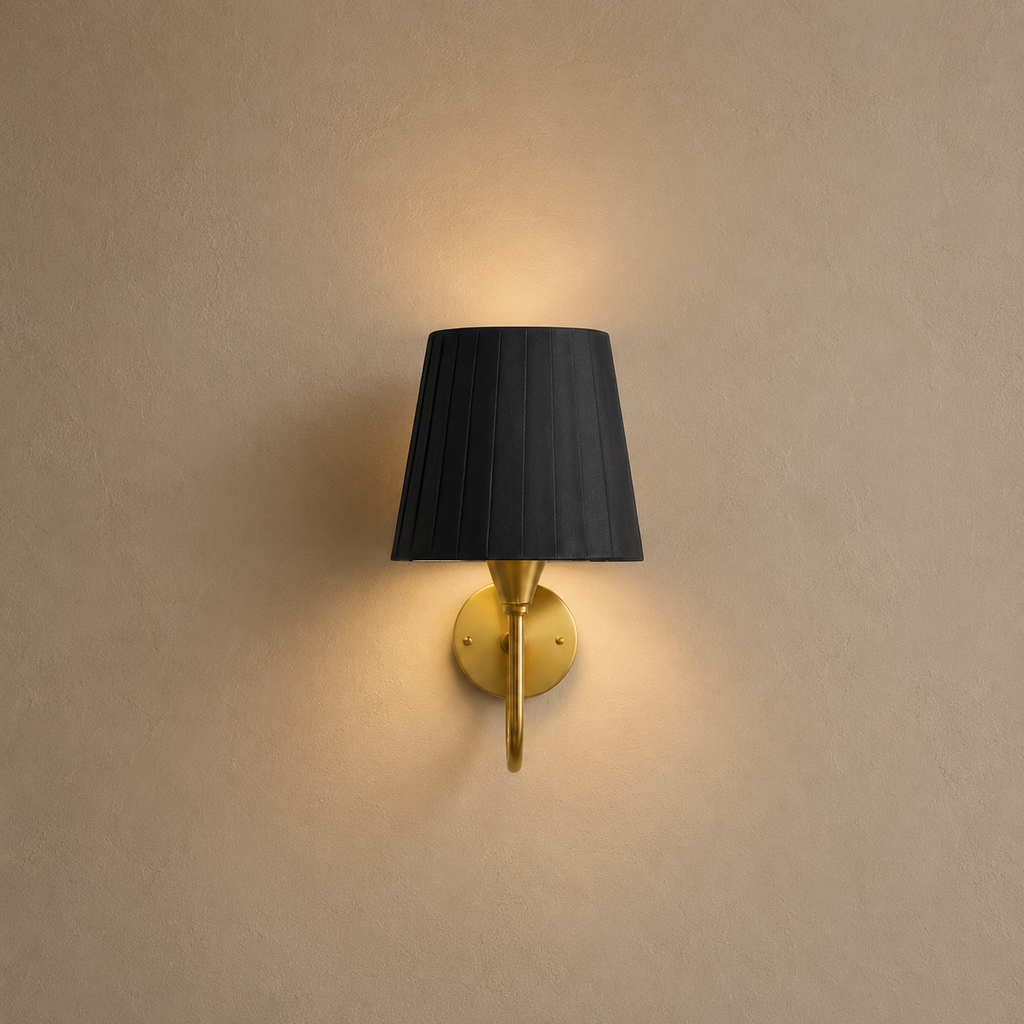 Wall-mounted lamp with black shade and gold fixture on a beige wall
