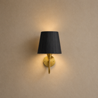 Wall-mounted lamp with black shade and gold fixture on a beige wall