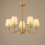 Gold chandelier with five lampshades on a beige background