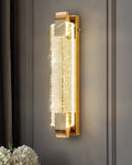 Gold wall sconce with crystal design on a gray wall