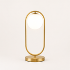 Gold table lamp with a white shade on a light beige background