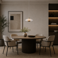 Dining room with a round wooden table and chairs, featuring a modern light fixture and wall art.