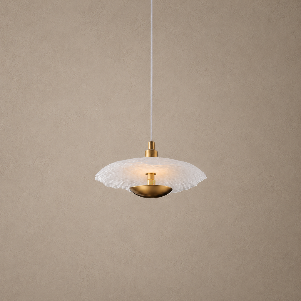 Pendant light with white glass shade and gold fixture on a beige background