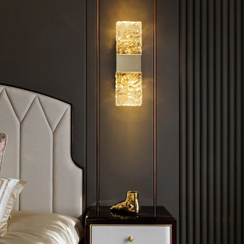 Decorative wall sconce on a dark wall above a nightstand with a gold boot ornament.
