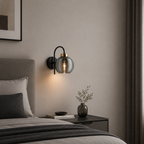 Modern bedroom with a wall sconce, bed, and nightstand.