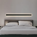 Modern bedroom with a bed and wall-mounted light fixture.