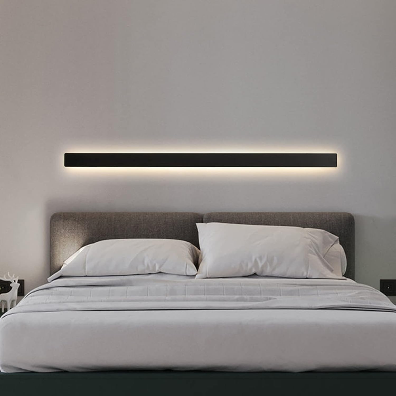 Modern bedroom with a bed and wall-mounted light fixture.