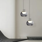 Two modern pendant lights hanging from the ceiling in a minimalistic interior setting.