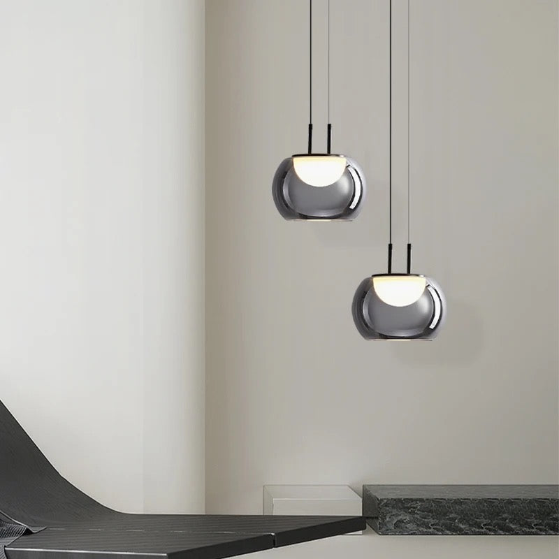 Two modern pendant lights hanging from the ceiling in a minimalistic interior setting.