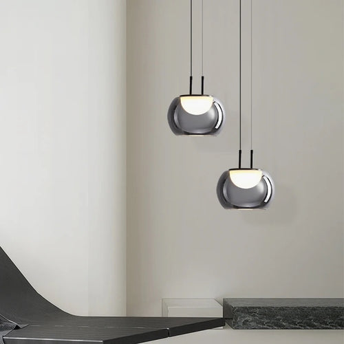 Two modern pendant lights hanging from the ceiling in a minimalistic interior setting.