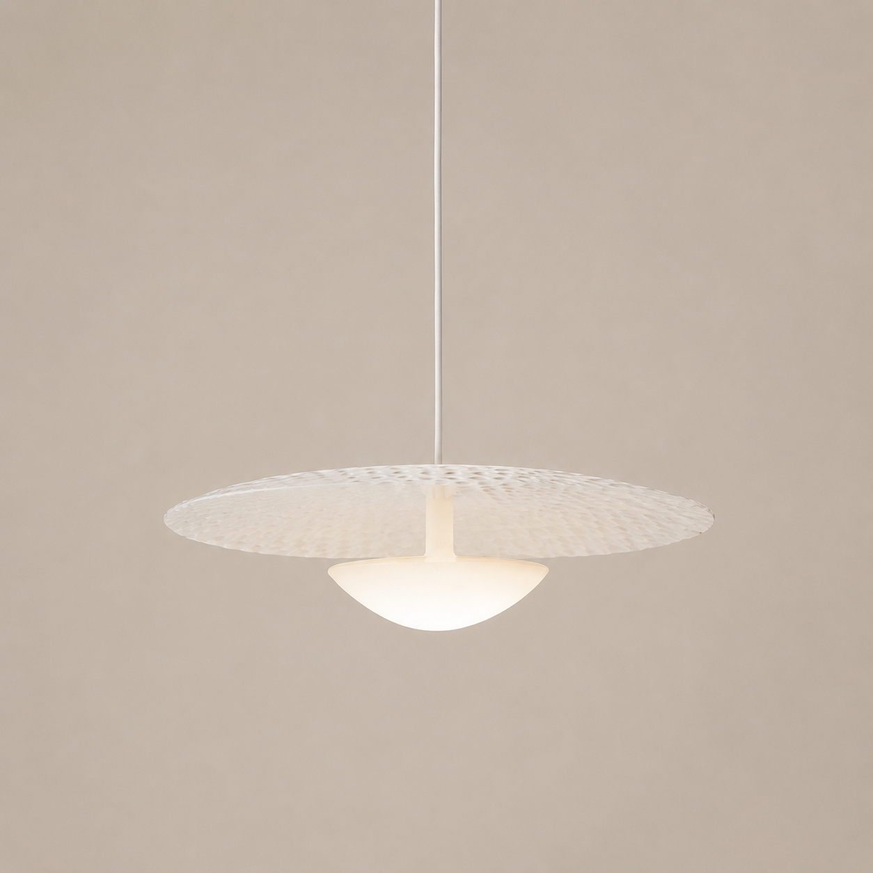 Modern pendant light with textured shade on a beige background
