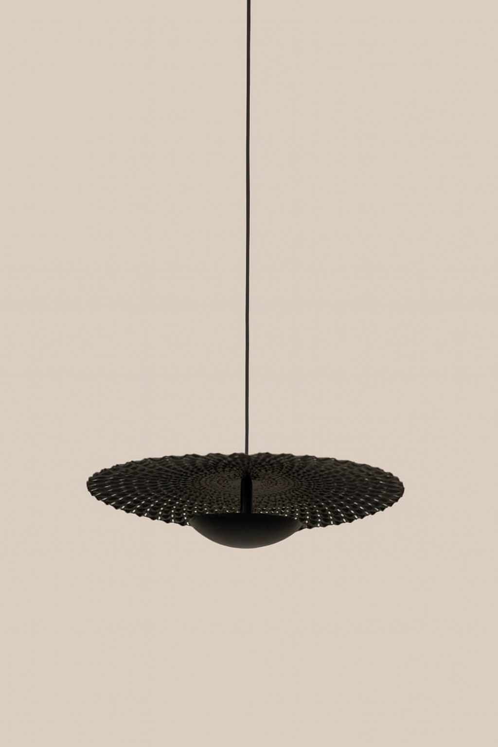 Black pendant light fixture on a beige background