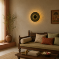 Decorative wall light fixture in a living room with a wooden sofa and decorative items.