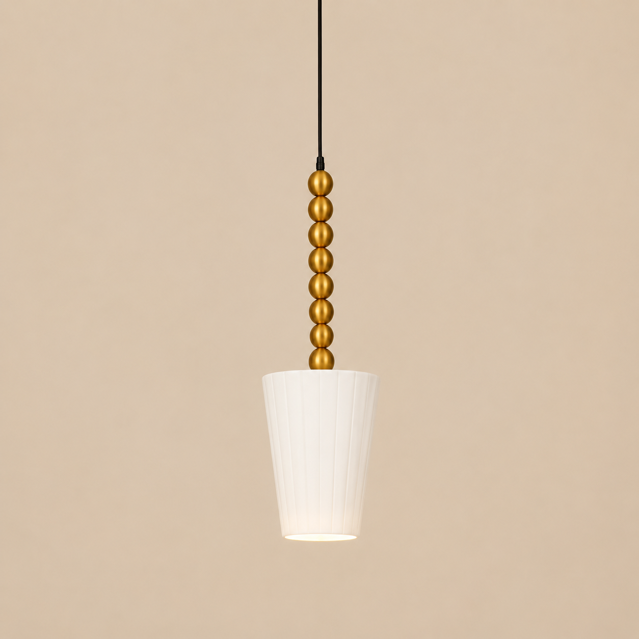 Pendant light with gold bead detailing on a beige background