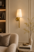 Decorative wall sconce with a lampshade in a living room setting.