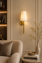 Decorative wall sconce with a lampshade in a living room setting.