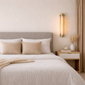 Neatly made bed with beige and white bedding in a bedroom setting.
