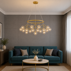Modern living room with a gold chandelier, teal sofa, and round wooden coffee table.