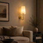 Cozy living room with a wall lamp, sofa, and decorative items.