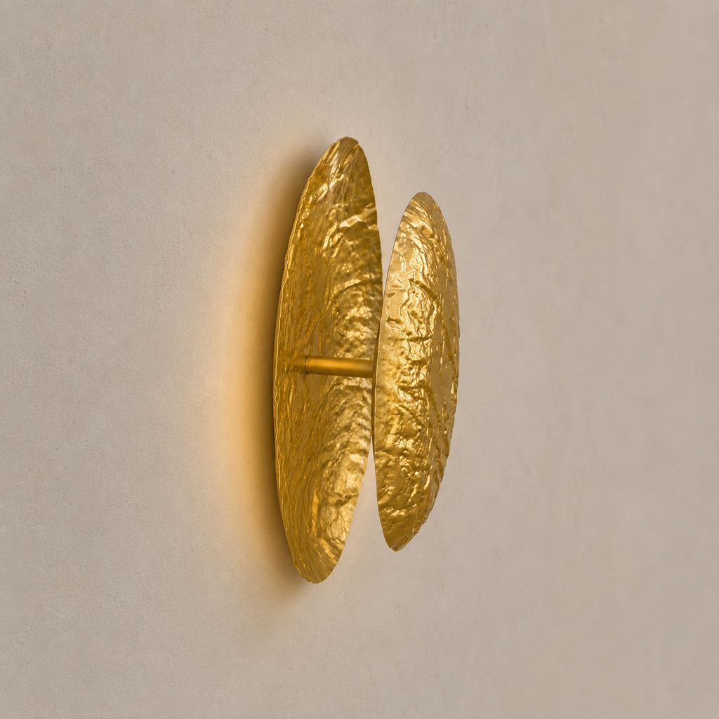 Gold wall sconce on a beige wall