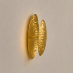 Gold wall sconce on a beige wall