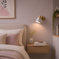Cozy bedroom with a bed, nightstand, wall lamp, and decorative elements.