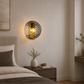 Decorative wall sconce in a bedroom setting with a bed and nightstand.