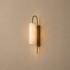 Wall-mounted lamp with a cylindrical shade on a beige wall