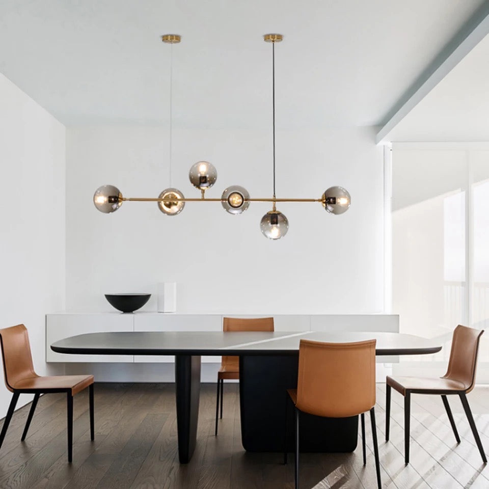 Modern dining room with a black table and brown chairs, featuring a stylish chandelier.