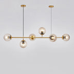 Modern gold pendant light with multiple glass bulbs on a plain background