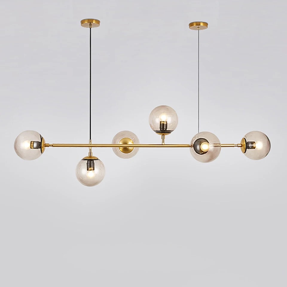 Modern gold pendant light with multiple glass bulbs on a plain background