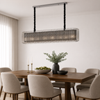 Dining room with a modern chandelier, wooden table, and chairs.