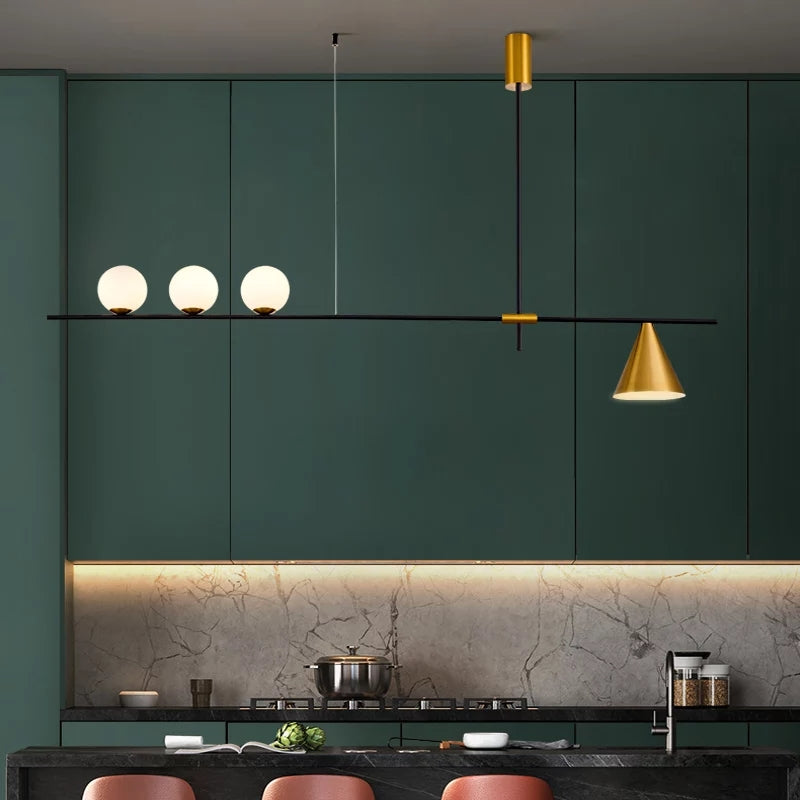 Modern kitchen with green cabinets, a gold pendant light, and marble countertop.