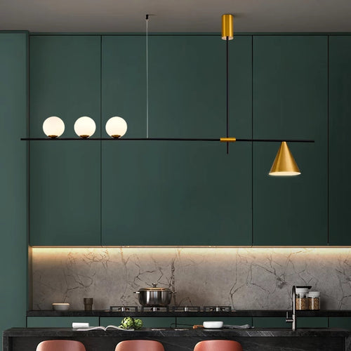 Modern kitchen with green cabinets, a gold pendant light, and marble countertop.