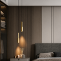 Modern bedroom with gray upholstered headboard, gold pendant lights, and a closet.