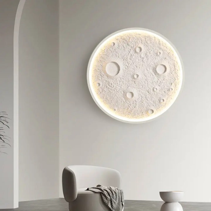 Modern wall clock with moon design on a white wall