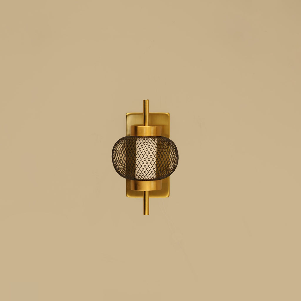 Gold wall sconce with mesh design on a beige background