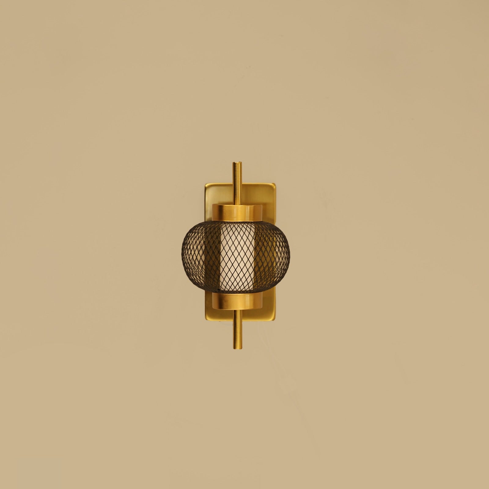 Gold wall sconce with mesh design on a beige background