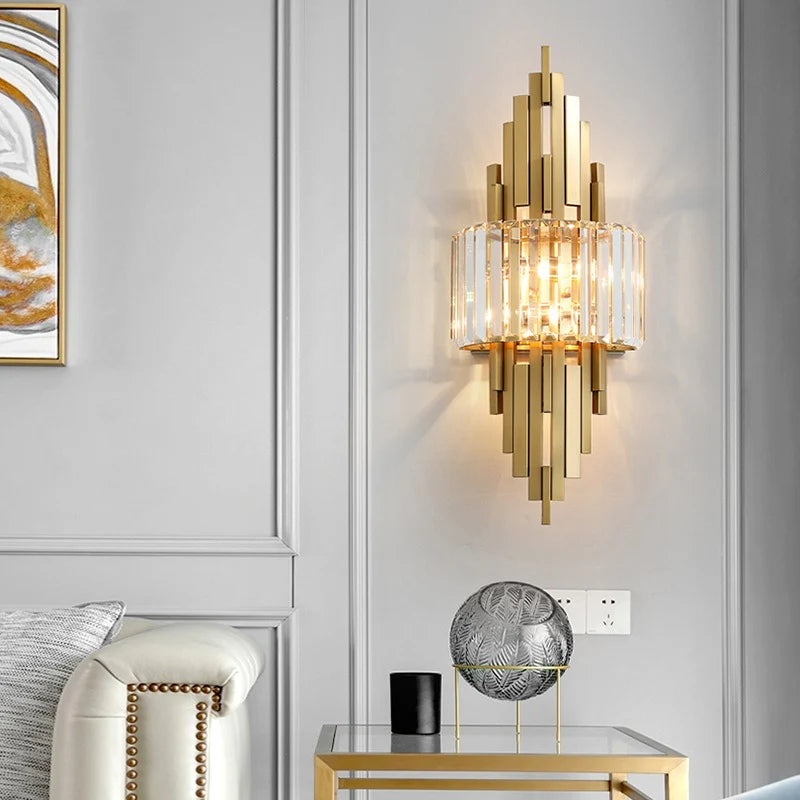 Gold wall sconce in a modern interior setting with a sofa and decorative items.